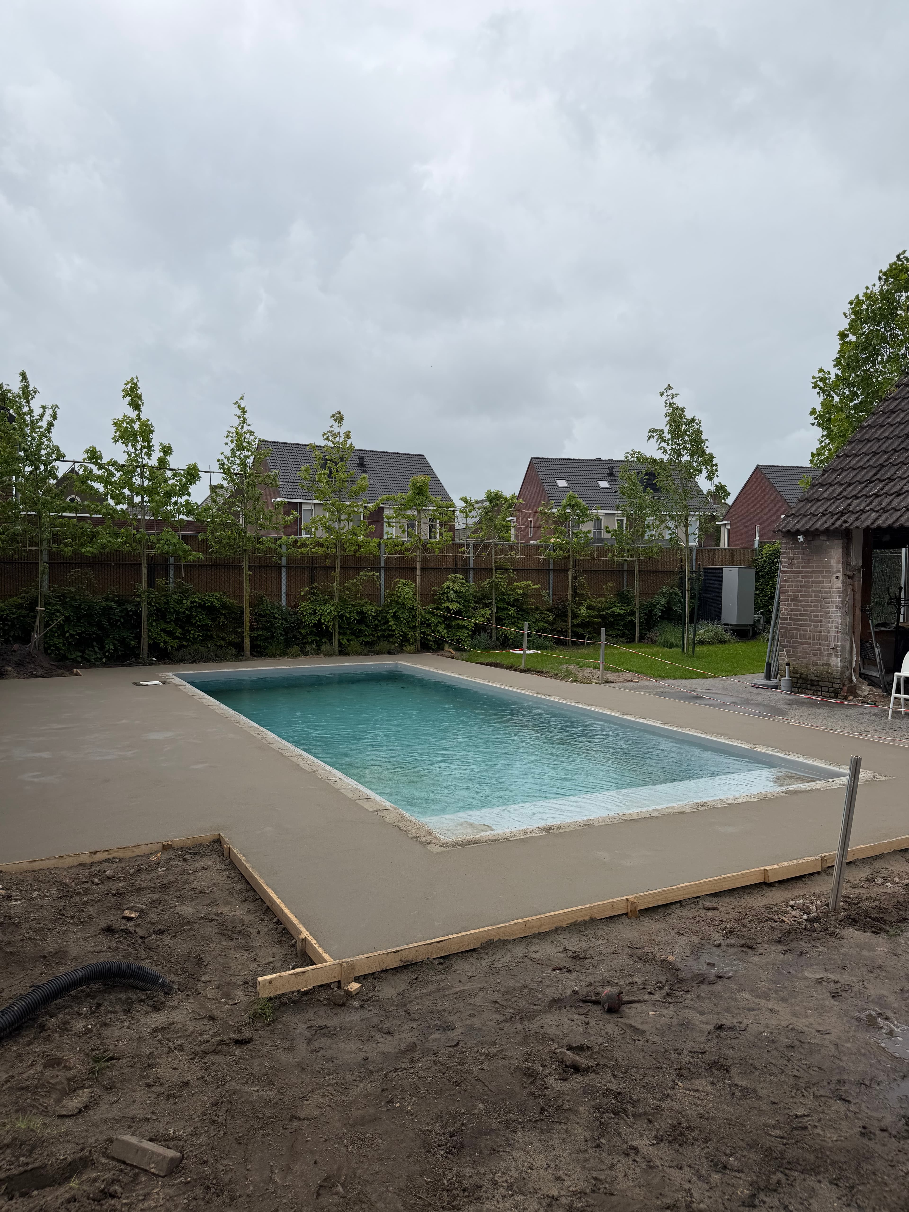 Zwembad met een vers aangebrachte vloer rondom het bad tijdens de werkzaamheden